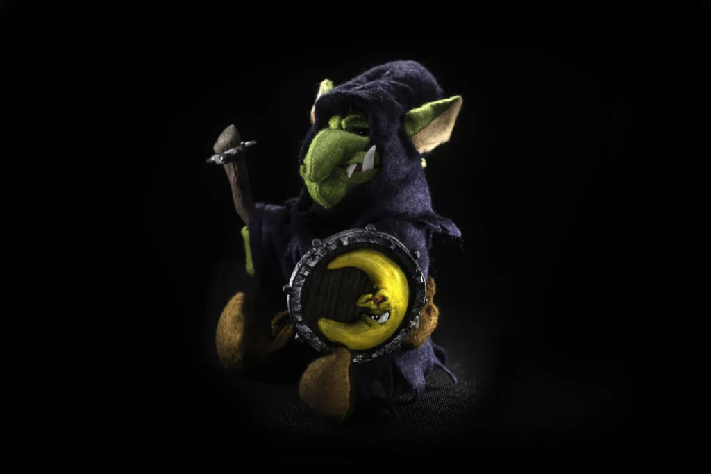 The Jongleurs Dream presents the Night Goblin plush collectible - A cuddly version of the sneaky and mischievous denizen of the grimdark fantasy realm, now reimagined as a premium soft toy. This detailed desk display piece captures its iconic hunched posture and menacing grin in soft fabric form, perfect for fans of dark fantasy and collectors of miniature tabletop game plush toys.